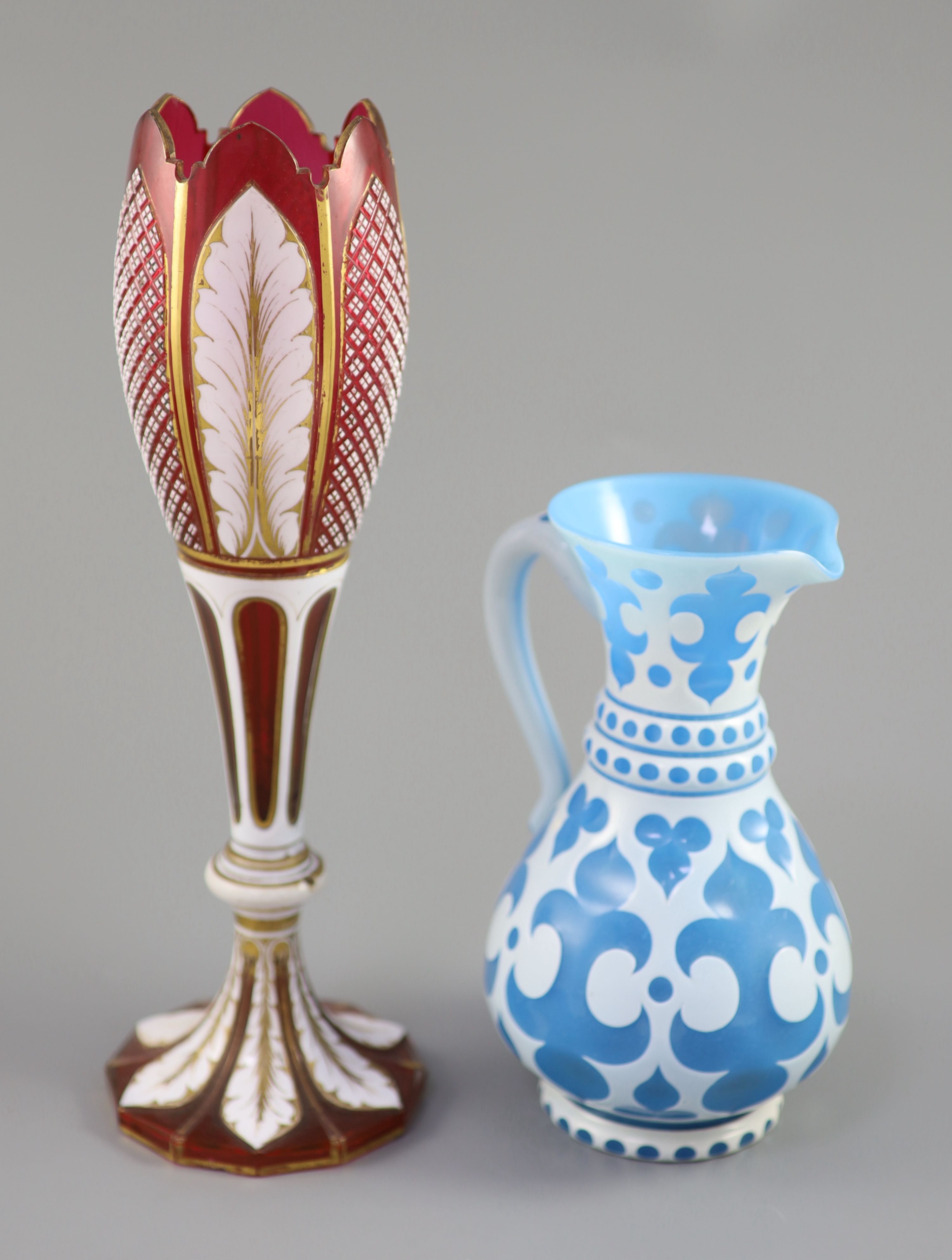 A Bohemian blue and white overlaid glass jug and a similar ruby and white overlaid glass vase, tallest 35cm